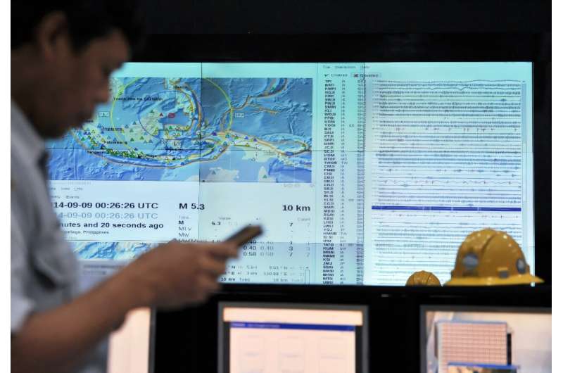 An Indonesian official checks his phone for an SMS earthquake and tsunami warning alert during an Indian Ocean-wide tsunami exercise to test readiness in case of a massive earthquake and tsunami alert