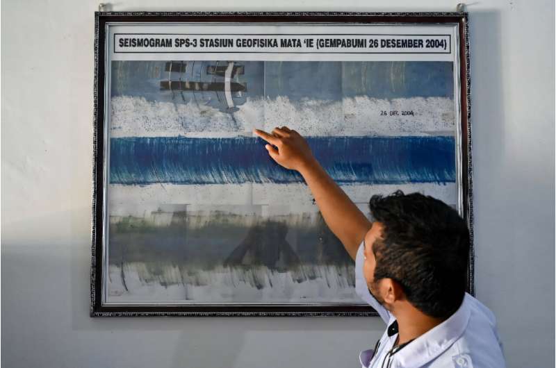 An officer from the geophysics center points to a seismograph system that recorded the 9.3 richter scale on the 2004 Indian Ocean earthquake and tsunami, at a monitoring station in Darul Imarah, Aceh province on December 23, 2024